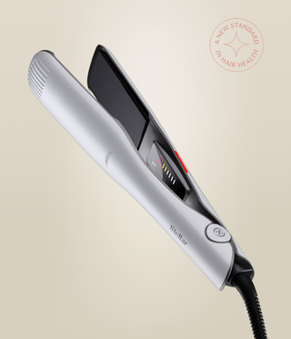 Pearl White Omnia Styler Max open at an angle, showing its black plates, controls and cord.